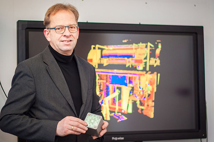 Stefan Seipel med en "range camera" som mäter en 3D bild. Bilden på skärmen i bakgrunden är en 3D laserskannad del av en industriell facilitet.